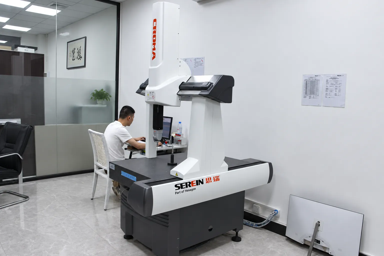 Coordinate measuring machine (CMM) probing a machined aluminum part on a granite table