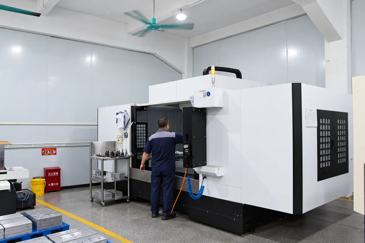 A machinist working at an open vertical machining center during a job setup