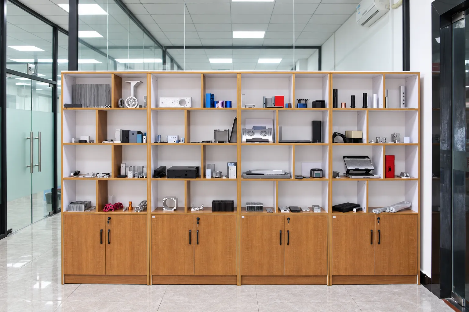 A sample cabinet holding machined aluminum housings, heat sinks, brackets and turned parts in several finishes