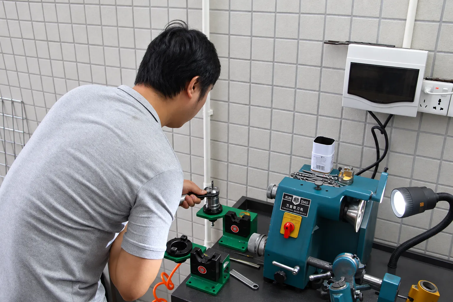 A technician regrinding a cutting tool on a tool and cutter grinder in the tool room